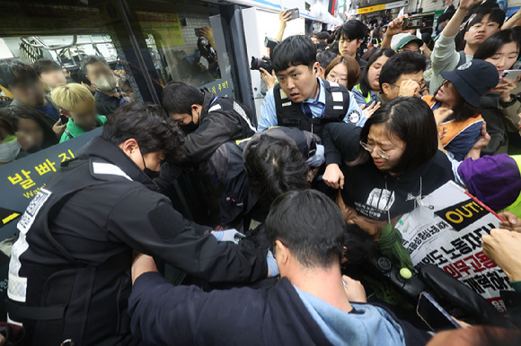 전국장애인차별철폐연대(전장연) 회원들이 21일 서울지하철 4호선 혜화역에서 제62차 '출근길 지하철 탑니다' 시위를 벌이던 중 지하철 탑승을 시도하며 서울교통공사 직원들과 충돌하고 있다. [사진=연합뉴스]