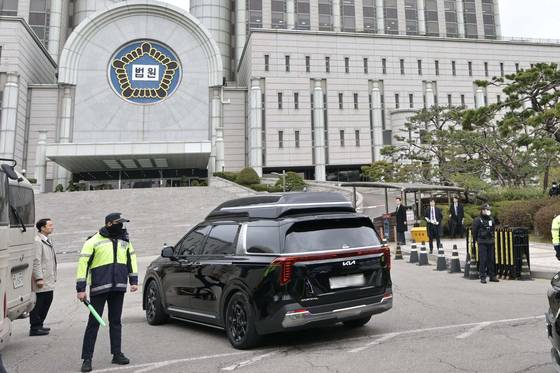 내란 우두머리 혐의로 기소된 윤석열 전 대통령의 첫 형사재판이 열리는 14일 윤 전 대통령이 탑승한 차량이 서울 서초구 서울중앙지방법원 지하주차장으로 들어가고 있다. 연합뉴스