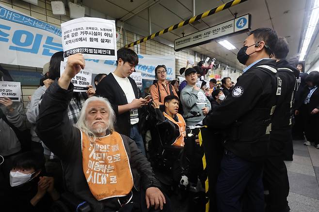 전국장애인차별철폐연대(전장연) 회원들이 21일 오전 서울 지하철 4호선 혜화역에서 제62차 ‘출근길 지하철 탑니다’ 시위를 벌이고 있다.  연합뉴스