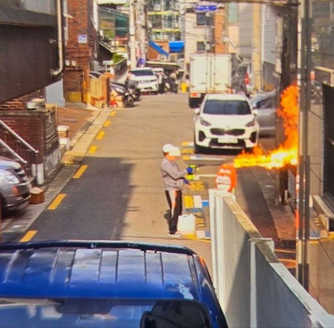 서울시 관악구 봉천동 아파트에 방화한 혐의를 받는 60대 남성 A씨가 화재 현장 인근에서 휘발유를 연결한 토치를 작동한 모습/사진=독자 제공