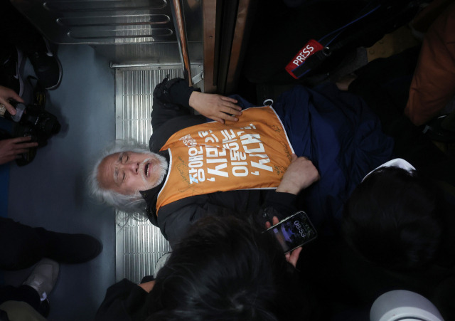 ▲박경석 전국장애인차별철폐연대(전장연) 공동대표가 21일 서울 지하철 4호선 혜화역에서 제62차 '출근길 지하철 탑니다' 시위를 벌이던 중 이를 저지하던 서울교통공사 관계자와 충돌하며 열차 입구에 넘어져 있다. 전장연이 출근길 지하철 탑승 시위에 나서는 것은 지난해 4월 8일 이후 1년여 만이다. ⓒ연합뉴스