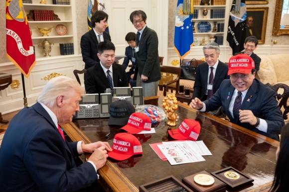 지난 16일(현지시간) 관세 협상을 하기 위해 미국 백악관을 찾은 일본 측 협상 대표 아카자와 료세이(오른쪽) 경제재생상이 도널드 트럼프(왼쪽) 미 대통령이 사인한 마가(MAGA·미국을 다시 위대하게) 모자를 쓰고 웃고 있다. 그는 트럼프 대통령과의 면담 뒤 기자들에게 “격이 낮은 저와 이야기해 주셔서 정말 감사하다”고 말해 일본 내에서 ‘저자세 외교’라는 비판이 제기됐다. 백악관 제공