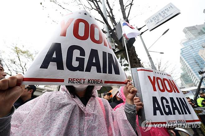 윤석열 응원하는 지지자들 (서울=연합뉴스) 김도훈 기자 = 내란 우두머리 혐의로 기소된 윤석열 전 대통령의 첫 형사재판이 열린 14일 서울 서초구 서울중앙지방법원 앞에서 윤 전 대통령 지지자들이 구호가 적힌 피켓을 들고 서 있다. 2025.4.14 superdoo82@yna.co.kr