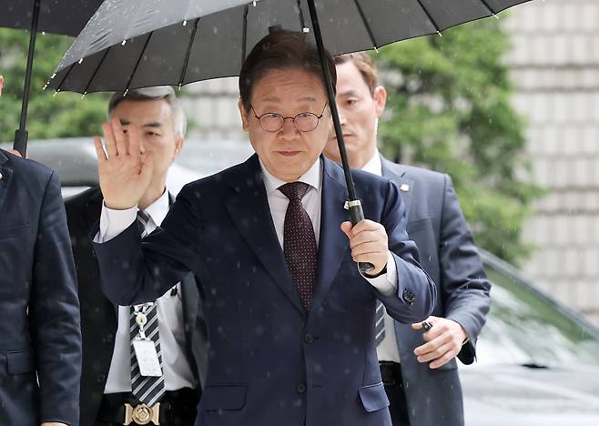 대권 도전에 나선 이재명 더불어민주당 전 대표가 22일 오전 서울 서초구 서울중앙지방법원에서 열린 '대장동 배임 및 성남FC 뇌물' 1심 공판에 출석하며 지지자들에게 손인사를 하고 있다. /뉴스1