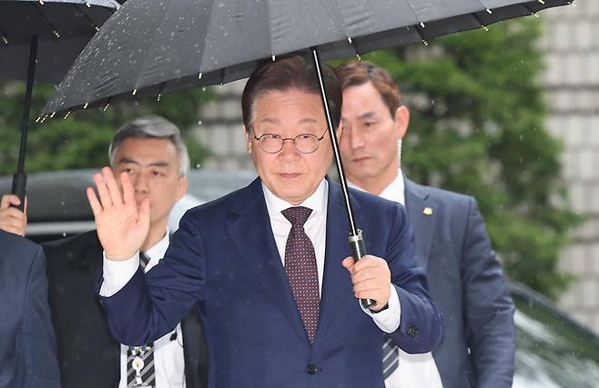 대권 도전에 나선 이재명 더불어민주당 전 대표가 22일 오전 서울 서초구 서울중앙지방법원에서 열린 ‘대장동 배임 및 성남FC 뇌물’ 1심 속행 공판에 출석하며 지지자들에게 손인사를 하고 있다. 뉴스1