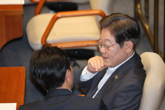 지난 4월17일 이재명 더불어민주당 전 대표가 국회 본회의에서 김민석 최고위원과 대화하고 있다.<연합뉴스 사진>