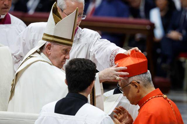 유흥식 라자로 추기경(오른쪽)이 2022년 바티칸 성베드로 대성전에서 열린 추기경 서임식에서 프란치스코 교황으로부터 추기경의 상징인 빨간색 사제 각모(비레타)를 받고 있다. 바티칸=EPA 연합뉴스