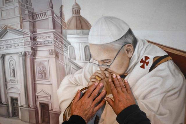 프란치스코 교황의 고향인 아르헨티나 부에노스아이레스 대성당에서 한 신도가 교황을 묘사한 그림을 만지고 있다. 부에노스아이레스=AFP 연합뉴스