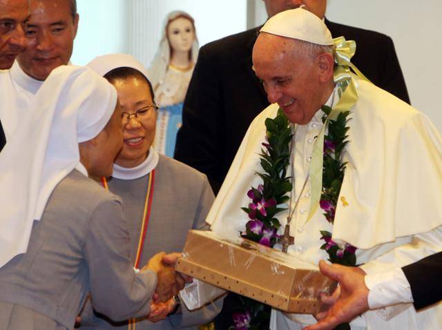 2014년 방한 당시 교황이 음성군 맹동면 꽃동네 희망의 집에서 수녀들이 준비한 선물을 전달받고 있다. 공동취재단