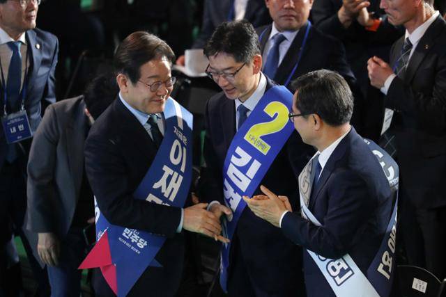 이재명·김경수·김동연 더불어민주당 대선 경선 후보가 19일 충북 청주체육관에서 열린 제21대 대통령선거 후보자 선출을 위한 충청권 합동연설회에서 결과 발표 직후 축하와 위로의 악수를 하고 있다. 청주=뉴스1