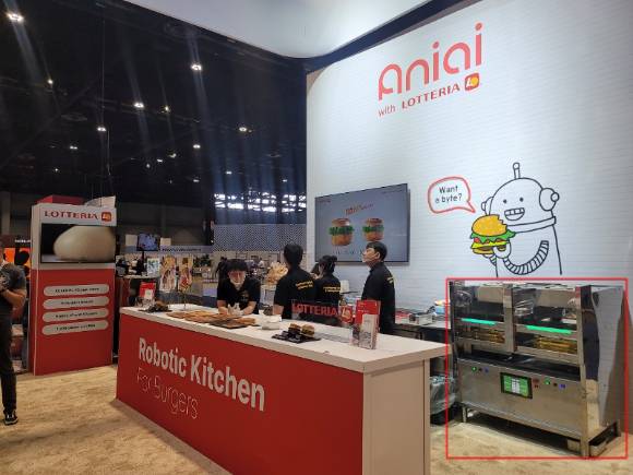 롯데GRS가 지난해 5월 미국 시카고에서 개최된 NRA 쇼에서 AI 로봇 기기 알파그릴(우측 하단)을 활용해 시식회를 진행하고 있다. [사진=롯데GRS]