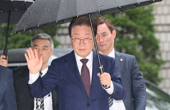 대권 도전에 나선 이재명 전 더불어민주당 대표가 22일 오전 서울 서초구 서울중앙지방법원에서 열린 '대장동 배임 및 성남FC 뇌물' 1심 속행 공판에 출석하며 지지자들에게 손인사를 하고 있다. 뉴스1