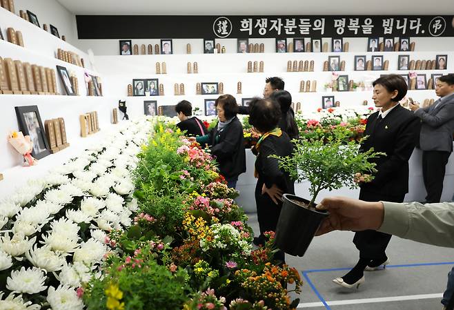 제주항공 여객기 참사 100일째인 지난 7일 무안공항에서 유가족들이 분향소 제단에 '봄꽃화단'을 설치하고 있다. 연합뉴스