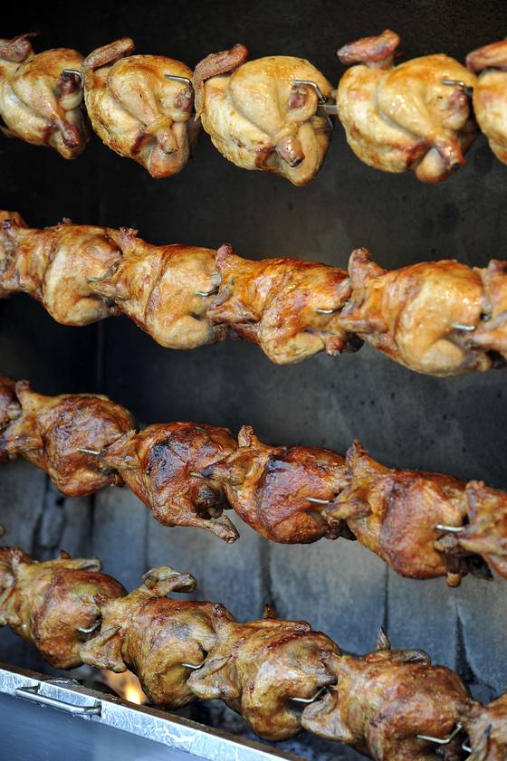 Rows of whole chickens glistening as they slowly spin over electric heat [JOONGANGILBO]