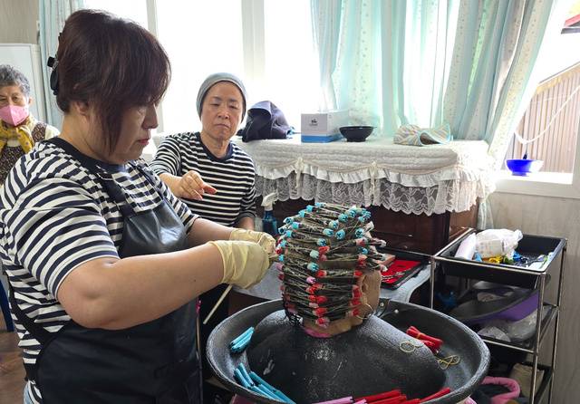 미용 봉사자가 섬 주민을 위해 파마를 해주고 있다.