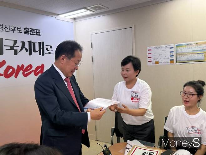 김다혜 국민의힘 중앙차세대여성위원회 위원장이 홍준표 국민의힘 대선 예비후보에게 정책 자료집을 건네고 있다. /사진=김서연 기자