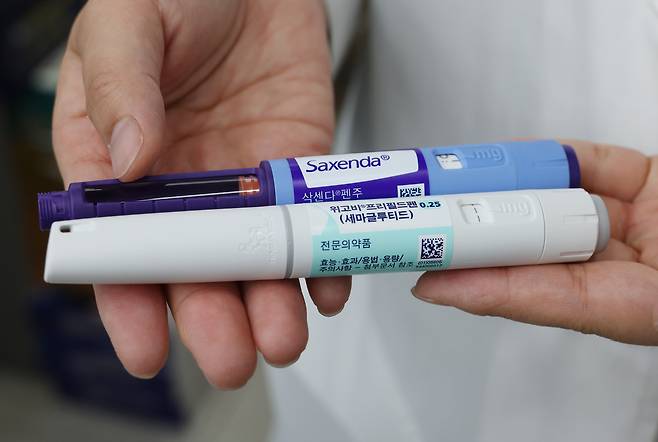 서울 종로 새종로약국에서 관계자가 위고비, 삭센다를 설명하는 모습. [연합]