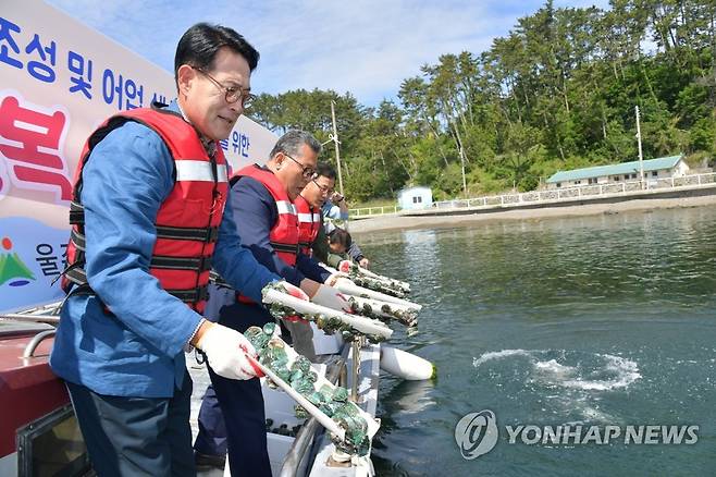 울주군, 마을어장 8곳에 전복 33만마리 방류 (울산=연합뉴스) 25일 울산시 울주군 서생면 송정항 앞바다에서 이순걸 군수(왼쪽)와 울주군의회 김상용 의원(왼쪽 두번째), 어촌계 관계자 등이 전복을 방류하고 있다. 2023.5.25 [울주군 제공. 재판매 및 DB 금지] leeyoo@yna.co.kr
