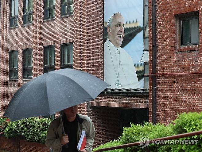 프란치스코 교황 선종 (서울=연합뉴스) 서명곤 기자 =  22일 서울 중구 명동대성당 영성센터 건물 외벽에 프란치스코 교황의 사진이 걸려있다. 서울대교구 주교단은 이날 오후 주교좌 명동대성당 지하성당에 프란치스코 교황 빈소를 마련한다고 밝혔다. 염수정 추기경, 정순택 대주교, 구요비 주교, 이경상 주교를 비롯한 주교단 조문 이후 오후 3시부터 일반인들도 조문할 수 있다. 2025.4.22 seephoto@yna.co.kr