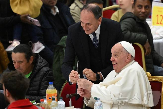 2024년 11월17일 프란치스코 교황의 개인 간호사 마시밀리아노 스트라페티가 가톨릭 기념일인 '세계 빈자의 날' 점심 식사에서 교황 옆에 서 있다.2024.11.17.ⓒ AFP=뉴스1
