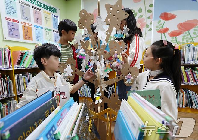 세계 책의 날을 하루 앞둔 22일 오전 경기 수원시 영통구 효동초등학교에서 5학년 학생들이 본인의 추천 도서를 적어 독서나무를 꾸미고 있다. 2025.4.22/뉴스1 ⓒ News1 김영운 기자
