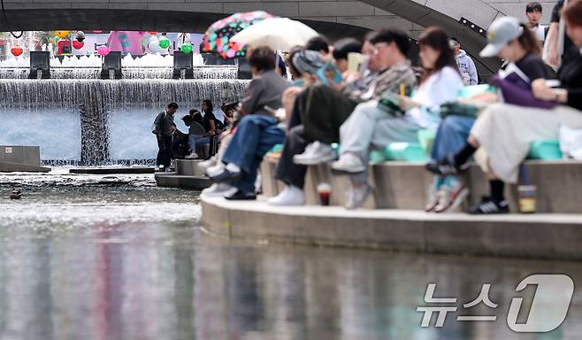 낮 최고기온이 25도를 기록하는 등 초여름 날씨를 보인 23일 오후 서울 중구 청계천을 찾은 시민들이 독서를 하고 있다. 2025.4.23/뉴스1 ⓒ News1 김성진 기자