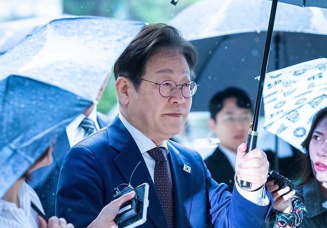 22일 서울 서초동 서울중앙지법으로 대장동 배임과 성남FC 뇌물 1심 재판을 위해 이재명 더불어민주당 대선 경선 후보가 우산을 들고 출두하고 있다./ 조인원 기자