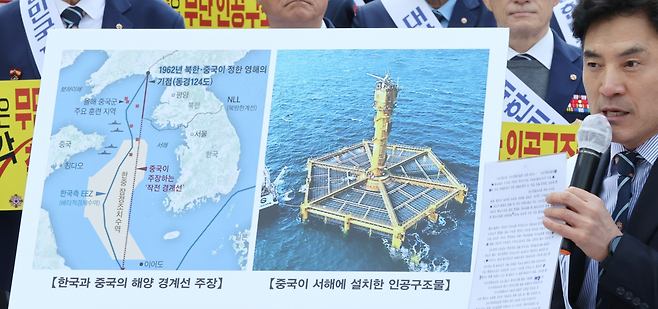 지난 3월31일 서울 중구 서울중앙우체국 앞에서 열린 ‘서해 무단 설치 중국 인공구조물 철거 촉구’ 집회에서 한 참석자가 구조물을 설명하고 있다. 연합뉴스