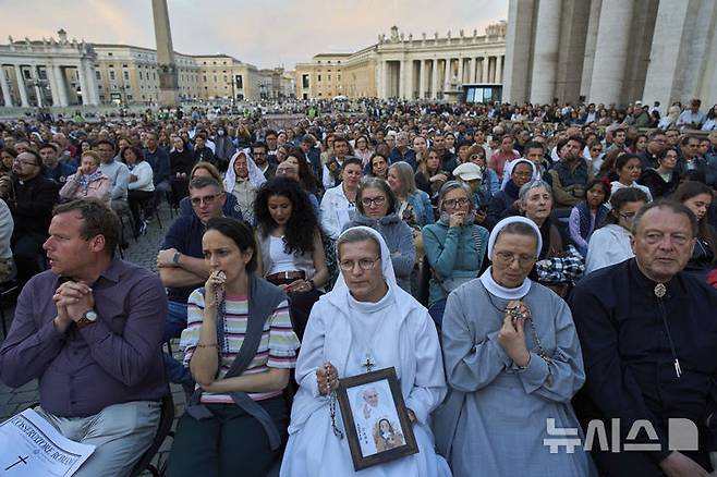 [바티칸=AP/뉴시스] 22일(현지 시간) 바티칸 성 베드로 광장에서 프란치스코 교황을 추모하는 묵주 기도회가 열려 참석자들이 기도하고 있다. 바티칸은 프란치스코 교황의 장례식을 오는 26일 오전 10시(한국 시간 오후 5시)에 거행하기로 하고, 교황의 시신이 안치된 관이 성 베드로 대성당으로 옮겨지는 23일부터 일반 신자들의 공개 조문을 받기로 했다. 2025.04.23.