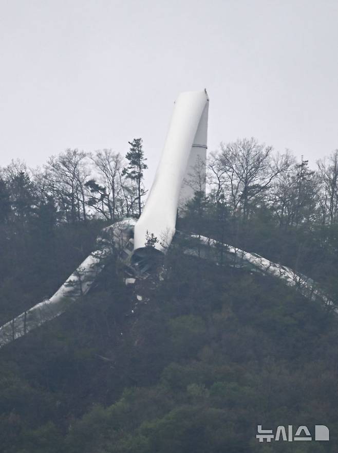 [화순=뉴시스] 김혜인 기자 = 23일 오후 전남 화순군 도암면 우치리 화학산 정상부에 지어진 127m길이의 4.7MW급 풍력발전기가 꺾여있다. 지난 21일 금성산 풍력발전 단지에 세워진 풍력발전기 11기 중 11번째 발전기가 쓰러진 것과 관련해 사고기의 시공·제조사 관계자들이 사고 원인을 밝히기 위해 현장 조사를 진행하고 있다. 2025.04.23. hyein0342@newsis.com