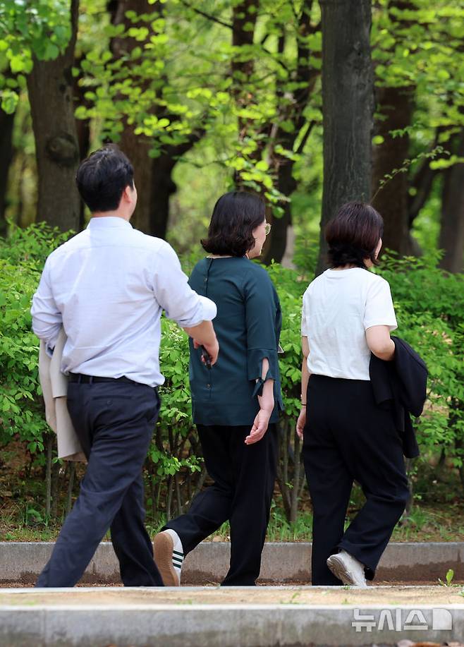 [서울=뉴시스] 이영환 기자 = 서울의 낮기온이 24도까지 오르며 초여름 날씨를 보인 23일 오후 서울 영등포구 여의도공원에서 시민들이 외투를 손에들고 이동하고 있다. 2025.04.23. 20hwan@newsis.com