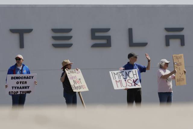 지난 12일(현지 시간) 미국 미주리주 캔사스 시티의 테슬라 매장 앞에서 일론 머스크 테슬라 최고경영자의 정부효율부 활동을 비판하는 시위대가 사위를 하고 있다. AP연합뉴스