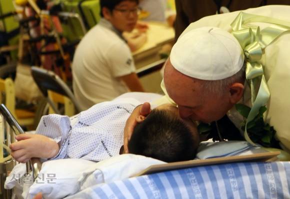 교황 프란치스코 1세 방한(2014.8.14~18) - 프란치스코 교황이 16일 음성군 맹동면 꽃동네 희망의 집에서 오미현 양의 이마에 키스를 하고 있다. 공동취재단