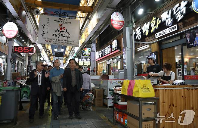 유인촌 문화체육관광부 장관이 23일 산불 피해 지역인 경북 안동을 찾아 안동구시장의 찜닭 골목에서 상인과 인사를 나누고 있다.