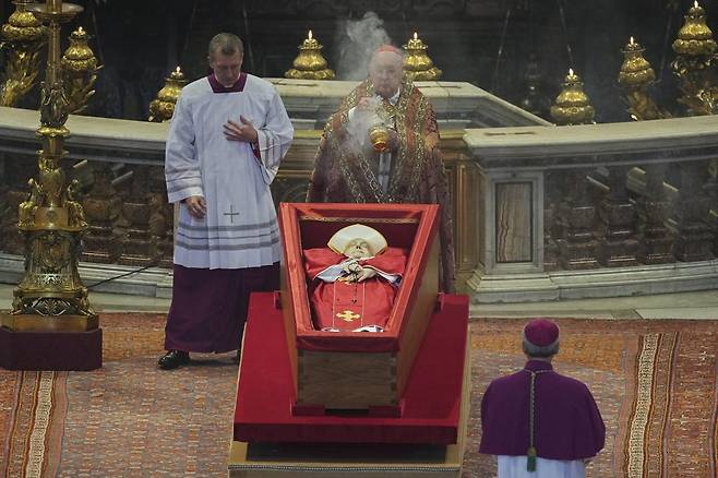 23일(현지 시간) 바티칸의 성 베드로 대성당에서 궁무처장 케빈 조셉 패럴 추기경이 프란치스코 교황의 시신 주위에 향을 뿌리고 있다. 프란치스코 교황의 시신은 사흘간 대성당에 안치돼 일반 신자들의 조문을 받는다. 2025.04.23 바티칸시국=AP 뉴시스