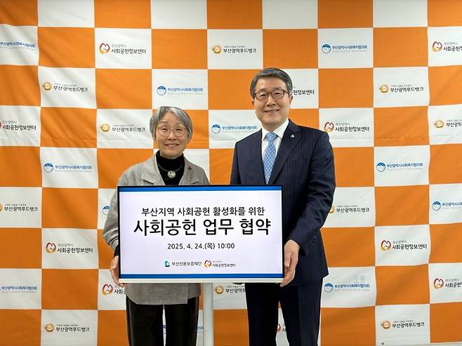 부산신보 성동화 이사장(오른쪽)과 부산시사회공헌정보센터 오흥숙 센터장이 업무협약 기념촬영을 하고 있다. 부산신보 제공