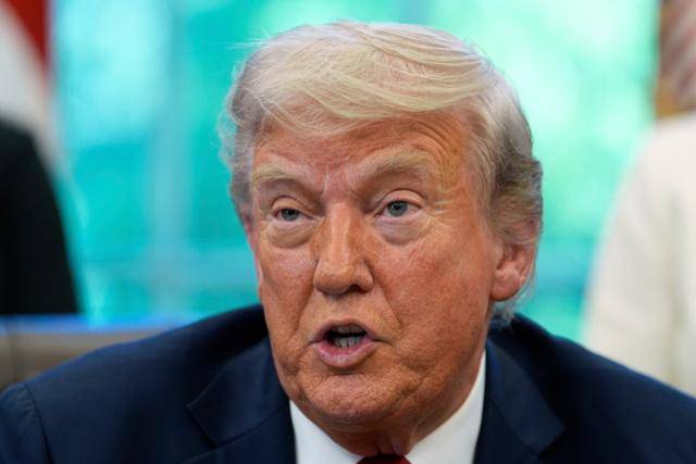 도널드 트럼프 미국 대통령이 23일 워싱턴 백악관 집무실(오벌오피스)에서 행정명령에 서명한 뒤 기자들과 대화하고 있다. 워싱턴=AP 연합뉴스