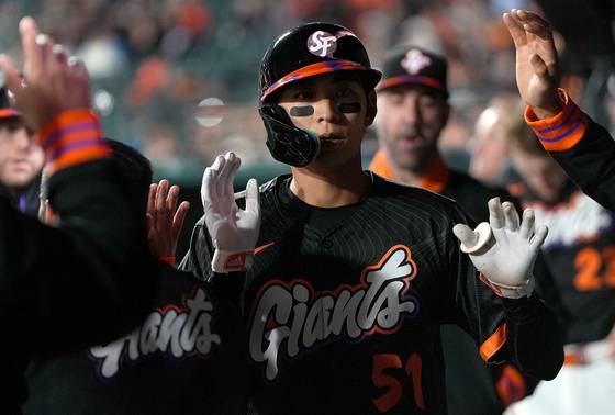 22일 밀워키전 8회말 득점 직후 더그아웃에서 동료들과 하이파이브를 나누는 이정후. 올 시즌 절정의 타격감을 앞세워 샌프란시스코의 중심 타자로 자리를 굳혔다. [AFP=연합뉴스]