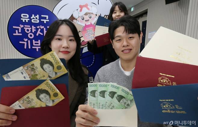 (대전=뉴스1) 김기태 기자 = 22일 대전 유성구청 직원들이 구에서 제작한 고향사랑기부제를 홍보할 수 있는 세뱃돈 봉투를 선보이고 있다.   세뱃돈 봉투는 유성구의 대표 캐릭터 '유성이'와 뱀을 활용해 디자인했으며, 다가오는 설 명절에 주민들이 사용할 수 있도록 동 행정복지센터와 커뮤니티 공간 등에 비치했다. 2025.1.22/뉴스1  Copyright (C) 뉴스1. All rights reserved. 무단 전재 및 재배포,  AI학습 이용 금지. /사진=(대전=뉴스1) 김기태 기자