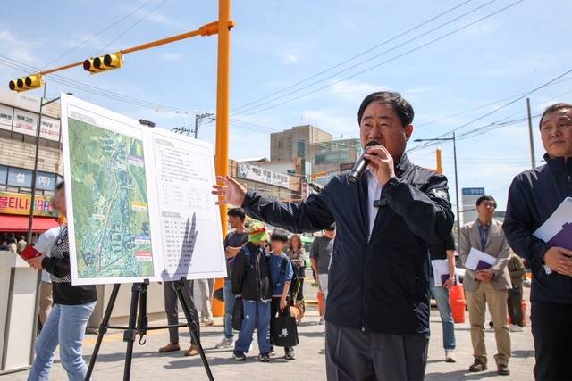 주광덕 남양주시장이 23일 퇴계원중학교에서 주공아파트를 잇는 도로확장공사 현장을 찾아 주민들과 대화를 나누고 있다. 남양주시 제공