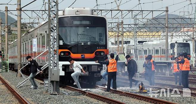 [부산=뉴시스] 하경민 기자 = 2025년 충무훈련의 하나로 '도시철도 피해복구 종합 실제훈련'이 열린 23일 부산 금정구 도시철도 1호선 노포차량정비창에서 테러를 당한 도시철도 승객들이 대피하고 있다. 전시 적 공격으로 인한 도시철도 시설피해 발생에 대비한 민·관·군·경·소방 합동훈련에는 53사단 부산여단과 부산교통공사, 금정구청, 금정소방서, 보건소, 부산항만공사, 금정결찰서 등 7개 기관 200여 명이 참가했다. 2025.04.23. yulnetphoto@newsis.com