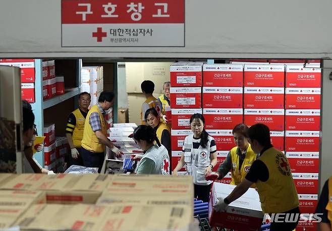 [부산=뉴시스] 하경민 기자 = 대한적십자 부산지사 직원들이 2일 오후 부산 부산진구 부산적십자회관 구호창고에서 여름철 재난 발생에 대비한 긴급 구호물품 1500세트를 점검 후 비축하는 작업을 하고 있다.  긴급구호물품은 담요, 운동복, 속내의, 양말, 화장지, 안대, 면도기, 세면도구 등으로 구성됐다. 2024.07.02. yulnetphoto@newsis.com