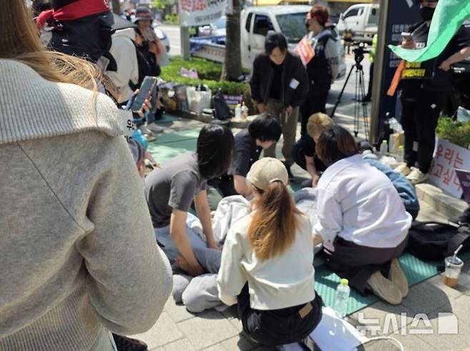 [서울=뉴시스] 고재은 수습 기자 = 24일 오전 서울 성북구청 앞에서 열린 성노동자 강제이주 반대 집회 현장에서 한 시위 참가자가 격한 감정을 표출하면서 드러눕자 주변인이 이를 만류하고 있다. 현장에는 119 구급대가 긴급 출동해 해당 시위자를 후송했다. 2025.04.24. jeko@newsis.com