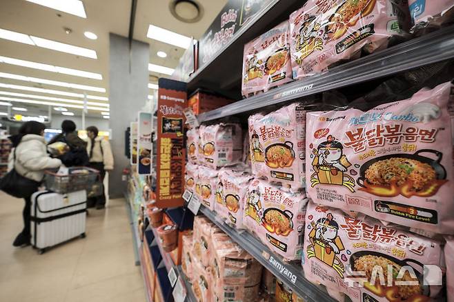 [서울=뉴시스] 정병혁 기자 = 서울시내 대형마트를 찾은 여행객이 K푸드로 인기를 끌고있는 불닭볶음면을 살펴보고 있다. 2025.03.05. jhope@newsis.com