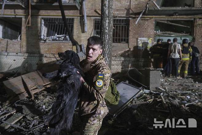 [키이우=AP/뉴시스] 24일(현지 시간)러시아의 공습으로 파손된 우크라이나 키이우의 주택가에서 우크라이나 군인이 강아지를 대피 시키고 있다. 비탈리 클리치코 키이우 시장은 러시아의 대규모 공격으로 최소 2명이 숨지고 6명의 어린이와 임산부 등 54명이 부상했다고 밝혔다. 2025.04.24.