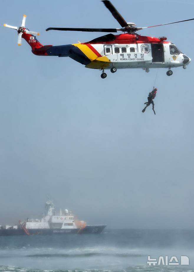 [부산=뉴시스] 하경민 기자 = 항공기 해상 불시착 상황을 가정한 수난대비 합동 구조훈련이 열린 24일 부산 강서구 진우도 인근 해상에 불시착한 모의항공기(500t급 경비함)에서 비상탈출한 승객을 해경이 헬기를 동원해 구조하고 있다. 이날 훈련에는 남해지방해양경찰청, 창원해양경찰서 등 13개 유관기관·단체에서 총 14척의 선박과 헬기 1기가 동원됐다. 2025.04.24. yulnetphoto@newsis.com