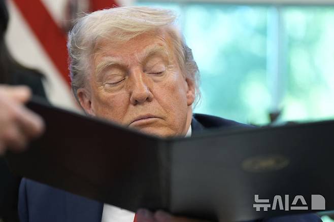 [워싱턴=AP/뉴시스] 도널드 트럼프 미국 대통령이 대중 관세 정책과 연방준비제도(Fed)에 강경한 입장을 유지하다 한 발 물러섰다. 사진은 도널드 트럼프 미 대통령이 23일(현지시각) 자신이 서명한 행정명령문을 윌 샤프 백악관 비서에게 넘겨주고 있는 모습. 2025.4.24.