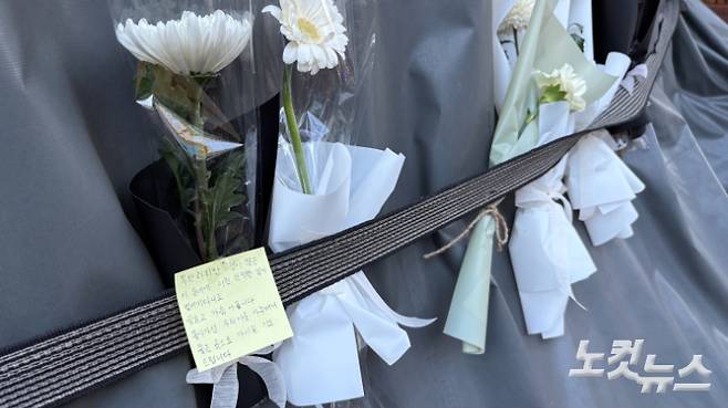 23일 서울 강북구 미아동의 흉기난동 사건이 발생한 마트 천막에 흰색 국화꽃과 함께 추모 메모지가 꽃혀 있는 모습. 김수정 기자
