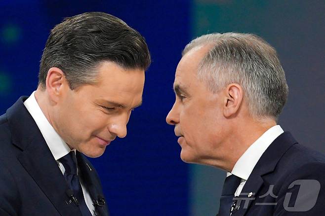 피에르 포일리에브르 보수당 대표(왼쪽)와 마크 카니 자유당 대표(총리)가 17일 몬트리올에서 열린 토론 행사에서 악수를 나누고 있다. 2025.4.17 ⓒ 로이터=뉴스1 ⓒ News1 강민경 기자