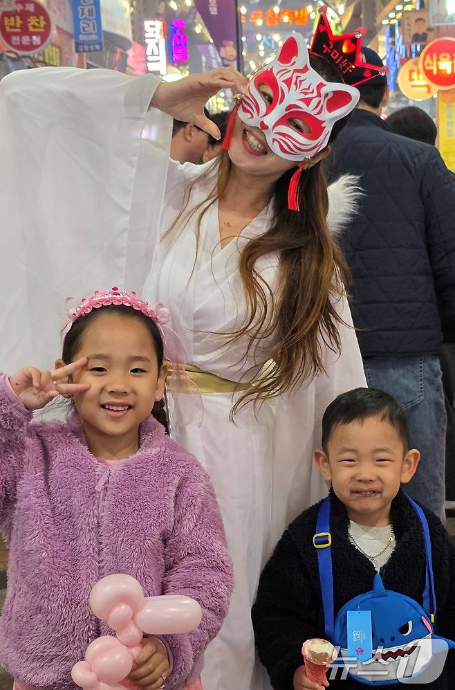 25일 구미 새마을 중앙시장에서 개장한 '달달한 낭만 야시장' 에서 야시장 캐릭터 구미호 걸이 아이들과 기념사진을 찍고 있다. 야시장은 5월17일까지 매주 금·토요일 열리며 5월23~24일과 구미 아시아육상경기선수권대회 기간인 27~31일에는 인동시장에서 문을 연다 2025.4.25/뉴스1 ⓒ News1 정우용 기자